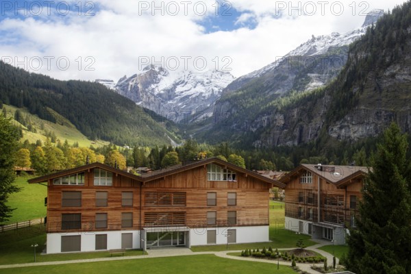 Wooden chalet in Kandersteg village, Canton Bern, Switzerland, Europe, Autumn trees and mountains