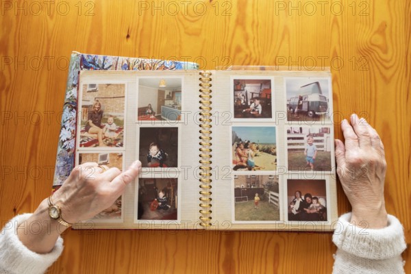 Top view of a senior caucasian woman looking at an old photo album themes of memories nostalgia