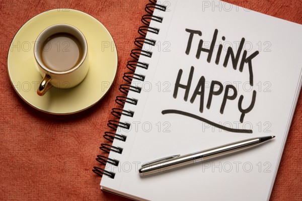 Think happy inspirational handwriting in a sketchbook with a cup of coffee, personal development,