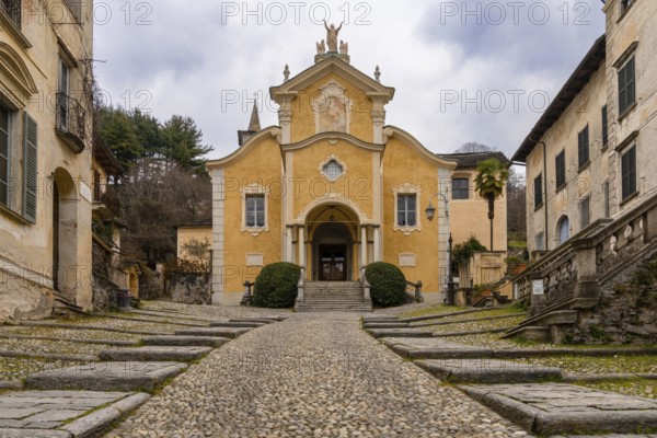 Orta San Giulio, Italy, 13 March, 2023: steep cobblestone street leading to the historic Penotti