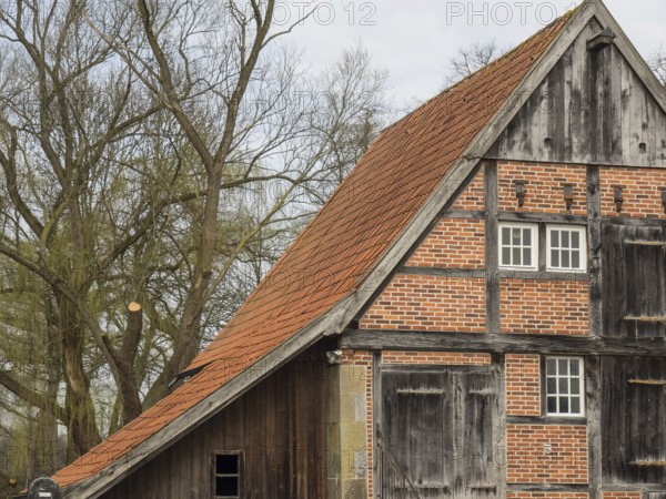 Half-timbered house with striking gable and red roof tiles. Rustic and old-fashioned building with