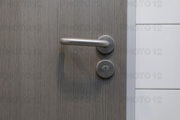 A stylish door handle rests on a beautiful wooden surface, perfectly showcasing modern design and