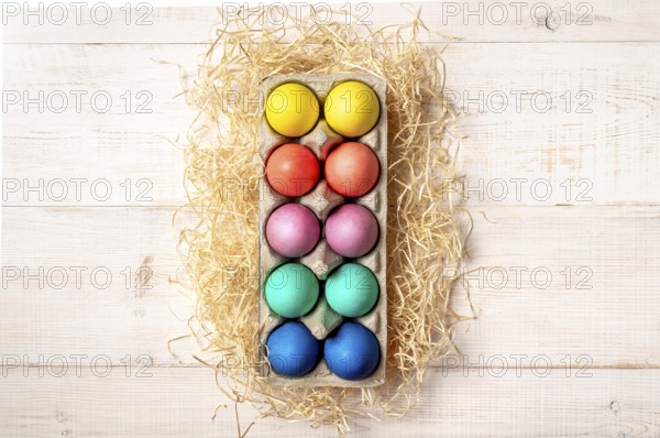 Easter concept. Colorful eggs on white wooden background with copy space for text or design. Top