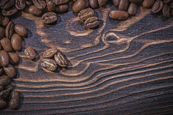 Roasted natural coffee beans on vintage wooden board
