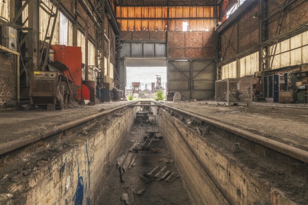 Old abandoned workshop with rails in the centre, numerous tools and rusty walls, steelworks HF4,