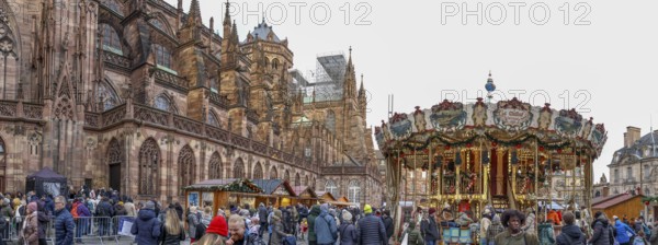 Panoramic photo of the carousel at the Christmas market at the High Gothic Strasbourg Cathedral,