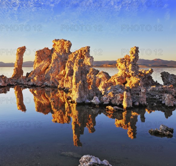 Orange sunset. The magic of Mono Lake. Outliers - calcareous tufa formation on the smooth water of