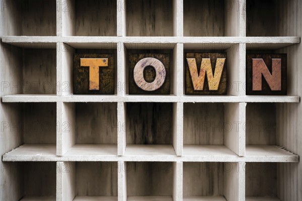 The word TOWN written in vintage ink stained wooden letterpress type in a partitioned printer's