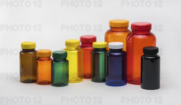 Multi colored transparent plastic pill jars on a white background. Isolated