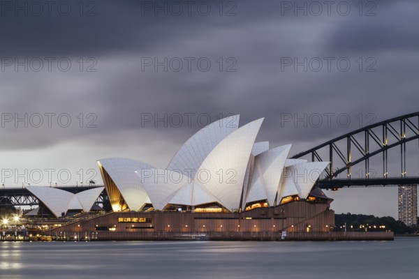 SYDNEY, AUSTRALIA, DECEMBER 03 2023: Sydney Opera House and Harbour Bridge at dusk during a summer