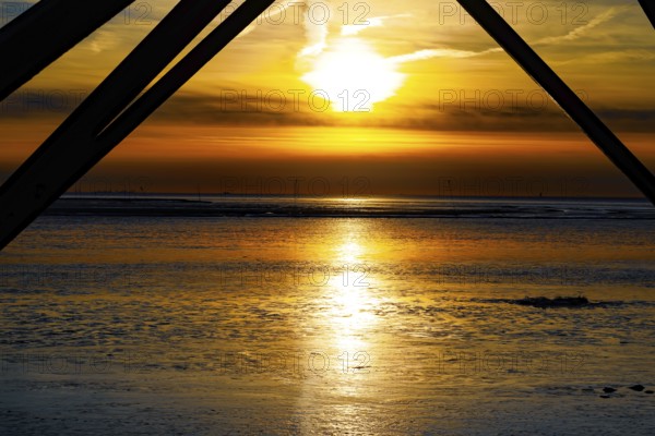 Sunset over the mudflats with dramatic colours and silhouettes in the foreground, Dorum-Neufeld