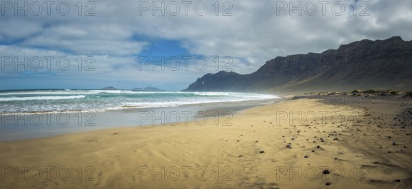 Panorama view on Famara beach on the Canary Island of Lanzarote, with some windsurfing in the far