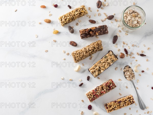 Granola bar with copy space. Set of different granola bars on white marble table. Shallow DOF. Top