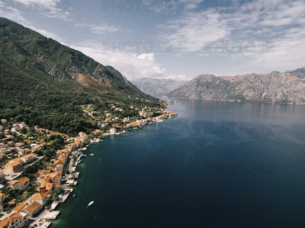 Red roofs of houses with private piers on the shores of the Bay of Kotor. Dobrota, Montenegro.