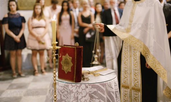 Wedding ceremony in an Orthodox church. The priest in a white cassock stand in the church at the
