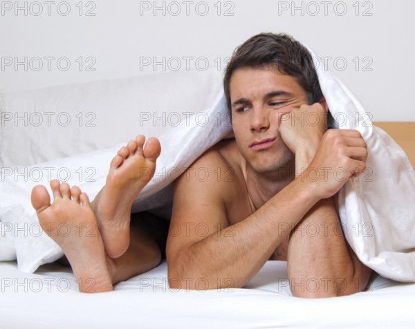 A young couple in bed having problems and crisis. Divorce and separation, A young couple in bed