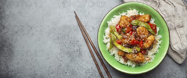 Asian sweet and sour sticky chicken with vegetables stir-fry and rice in ceramic bowl with