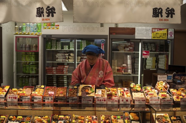 23 Dec 2017, Kyoto, Japan, Asia, A woman sells ready meals and drinks in a train station kiosk in