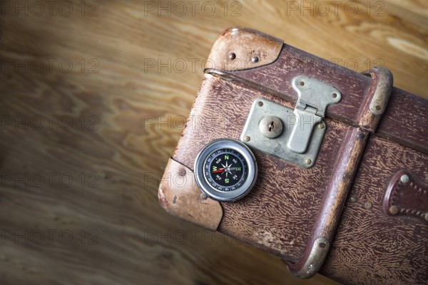 Old vintage suitcase with a compass seen from above, concept for travel, adventure and finding the