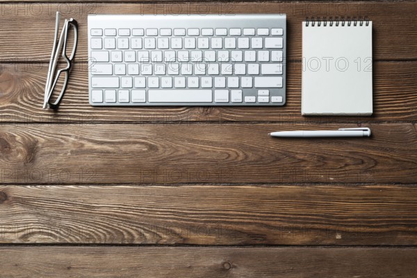 Still life of office workspace with supplies. Flat lay old wooden desk with white computer