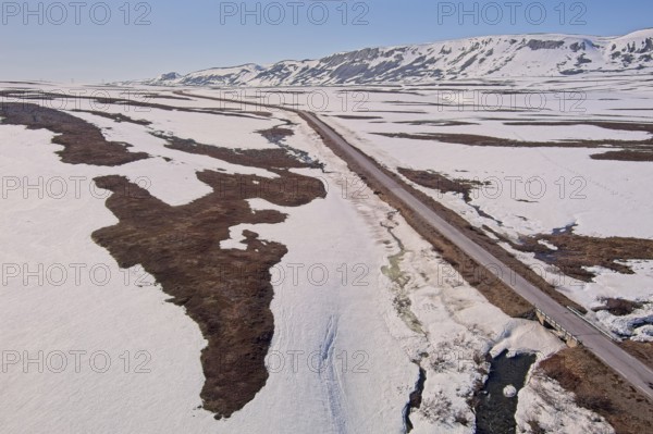 Aerial view of plateau landscape with snow covering the ground and Austertanaveien road 890 in