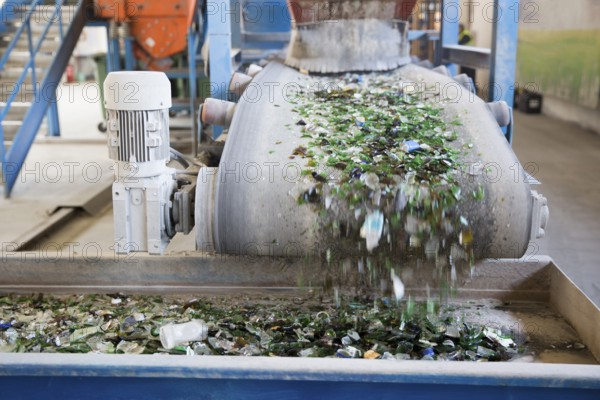 Glass particles for recycling in a machine in a recycling facility. Different glass packaging