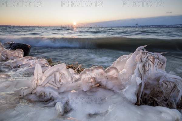 Snow-covered coastline, ice plants and waves at dusk, sunrise in the background, Hörnle, Constance,