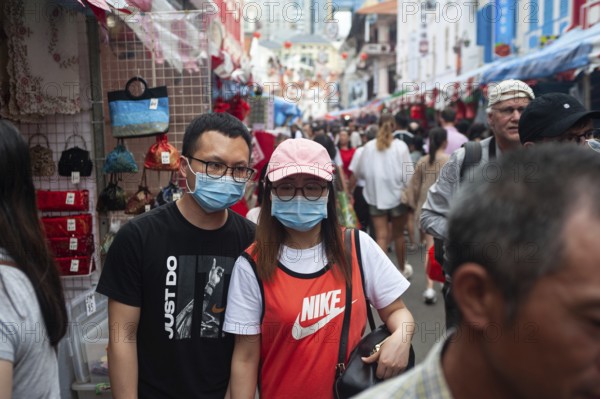 24.01.2020, Singapore, Republic of Singapore, Asia, Pedestrians wearing face masks stroll through a