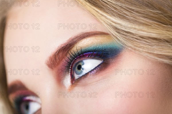 Close up portrait of a beautiful young blond model with bright make up. Close up of abstract