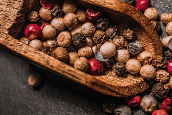 Different kind of peppercorns in a wooden spoon