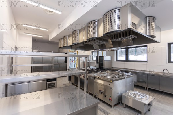 A contemporary commercial kitchen featuring stainless steel appliances and bright, efficient