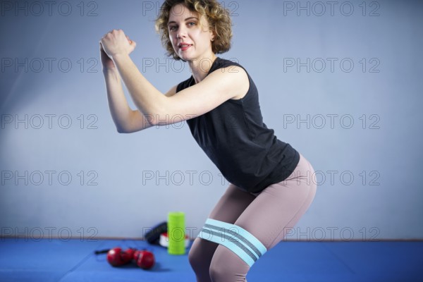 Legs woman barefoot doing pilates exercise with elastic fabric resistance band. Resistance Bands