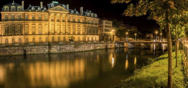 Night panoramic view with the Rohan Palace and the river Ill, with building and yellow lights