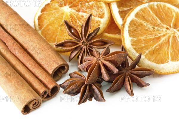 Cinnamon sticks, anise stars and orange slices on white background Cinnamon sticks, anise stars and