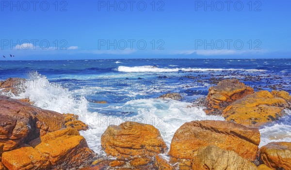 False Bay rough coast landscape with boulders waves and mountains with clouds in Glencairn Simons