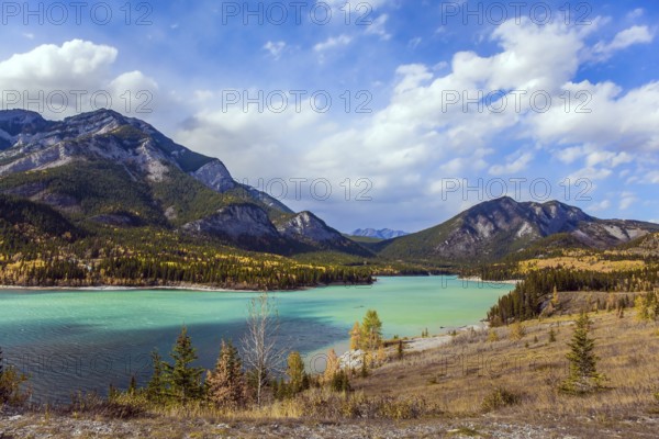 Lush multicolor autumn in the Canadian Rockies. The valley and azure icy water of the Kananaskis
