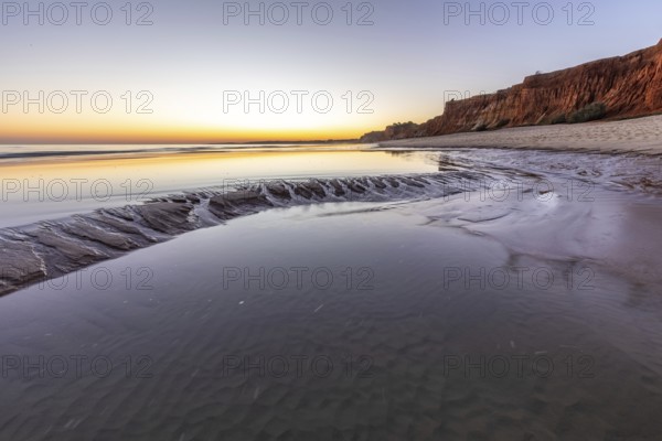 Sea with reflection at low tide in the calm waters of the Atlantic. Landscape shot of the sunset on