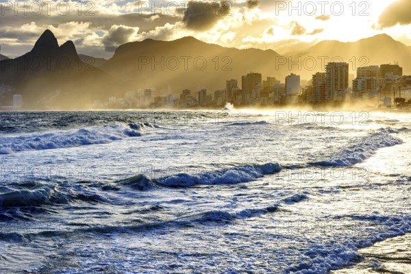 Summer sunset with cloudy sky with Two Brothers hill and Vidigal slum view from Ipanema beach at