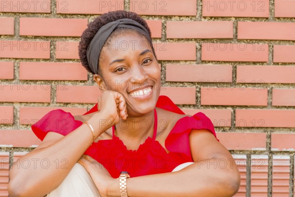 Woman sitting in front of a brick wall, smiling warmly with a headband and watch, Taken in Daejeon,