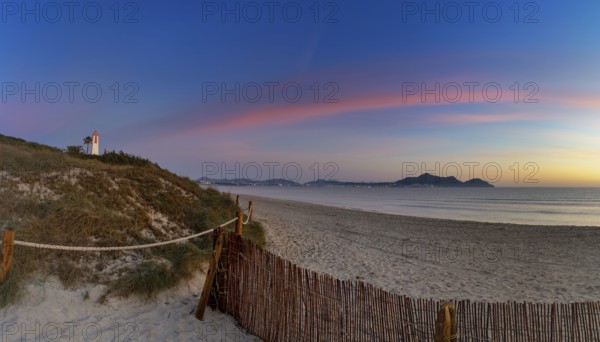 Picturesque Playa del Muro beach with sand dunes and a view of the historic maritime observation