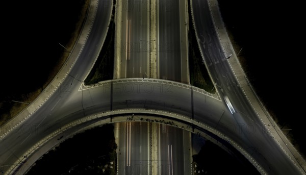 Aerial drone top view of a modern motorway junction roundabout with cars moving fast.