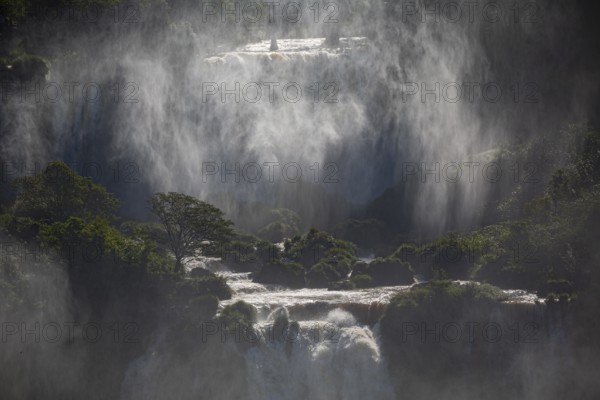 Mystical view to waterfall cascades with a wall of spray and sunlight, Iguazu Falls, Misiones,