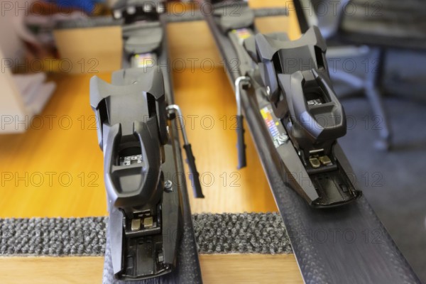 Ski center repair service shop, adjust the bindings and boots equipment on the table. Winter rent