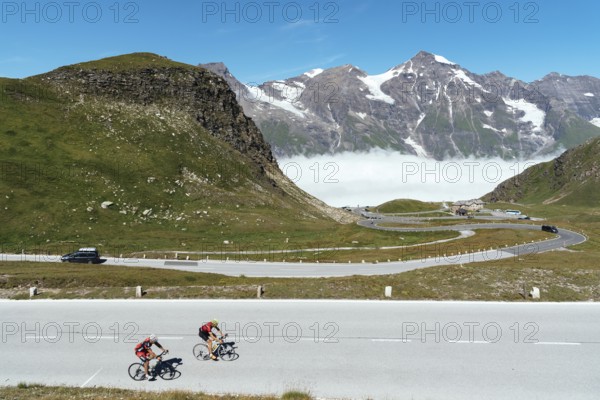 Grossglockner, Austria, August 7, 2017: Cyclists climbing mountain pass by Alpine road through