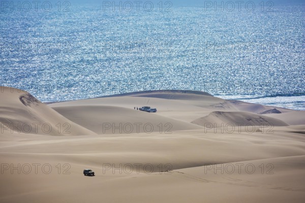 Gorgeous and dangerous jeep - safari through the huge sand dunes on the ocean shore. Atlantic coast