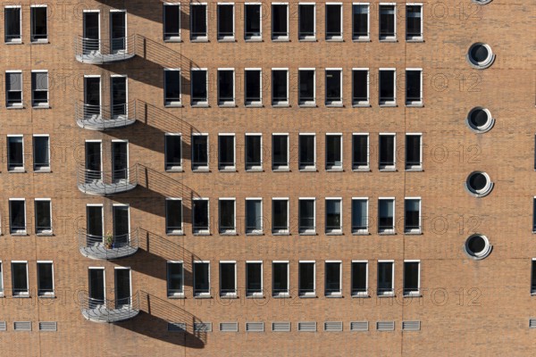 Red brick building with balconies and square and round windows in the Speicherstadt, Hafencity,
