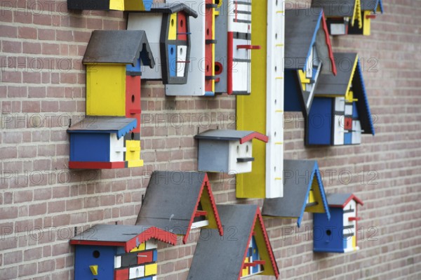 Many colorful birdhouses at the wall
