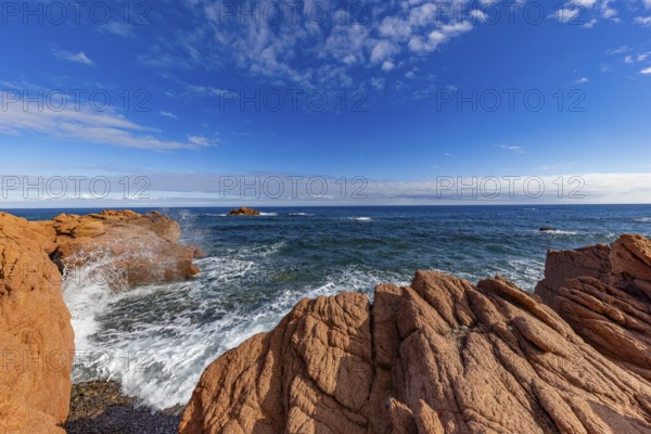 Coastal landscape with red rocks and surf in blue sky and sunshine, Spiaggia di Cala E'Luas,