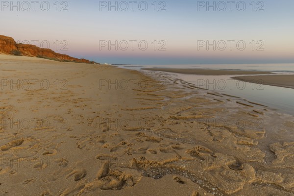 What a sandy beach on the Atlantic. Landscape shot at sunset on a coast with sandstone cliffs. Low