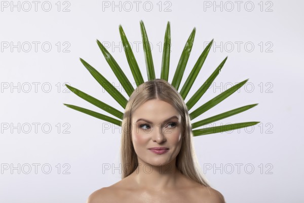 A creative portrait of a woman adorned with vibrant green leaves, symbolizing harmony between